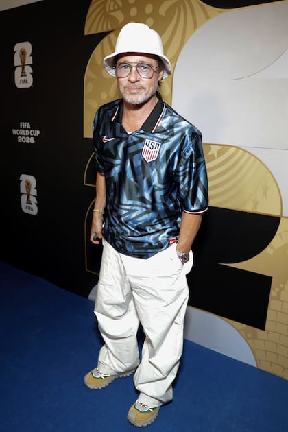 Para la cita, Brad Pitt eligió la camiseta de la selección de Estados Unidos, que combinó con un pantalón blanco y un gorro al tono. Ya instalado en la tribuna, se lo vio seguir el partido con atención mientras disfrutaba de unos vasos de cerveza