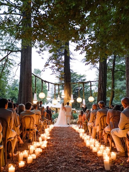 Para la ocasión, cuya temática fue estilo bosque encantado, los novios eligieron una decoración cálida con velas, flores blancas y luces colgantes que acompañaba el entorno natural
Fotos: @mauriciogaray_