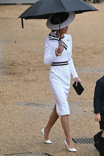 Para la ocasión eligió un sobrio vestido midi con ribetes en contraste, de estilo navy, y lazo en el hombro derecho de Jenny Packham. Lo combinó con pamela de Philip Treacy, stilettos Jimmy Choo, clutch Mulberry England y sus pendientes favoritos con perlas engastadas en diamantes de Cassandra Goad. El color predominante en su outfit, el blanco, representa la esperanza y el optimismo, sentimientos que la acompañan estos días.