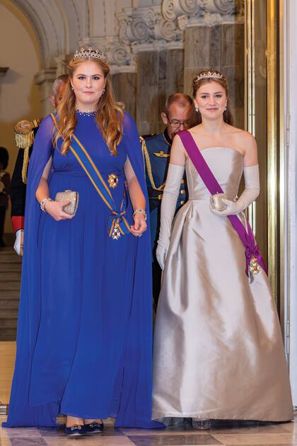 Para la velada, Amalia eligió un vestido con capa en tono azul Klein de la firma belga Essentiel Antwerp, que combinó con zapatos Manolo Blahnik, una imponente tiara -perteneciente a la reina consorte Emma- y un collar de panal (ambos, de zafiros). Ingresó junto a su amiga, la princesa Elisabeth de Bélgica, quien optó por un strapless de Natan estilo años 50 y zapatos Giorgio Armani. También lució por primera vez la tiara de Wolfers de dos hileras de diamantes, que fue un regalo a la reina Fabiola en su boda, en 1960.