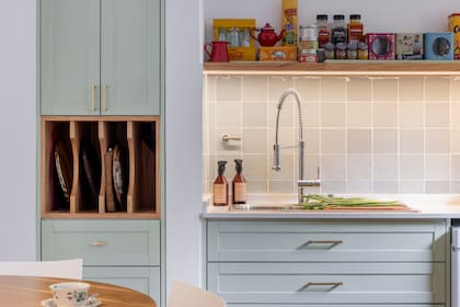 "Para mí era importante sentarme y ver algo lindo, no sentirme en la cocina". A eso aporta la vista a objetos queridos y los azulejos (Syria Cerámicos), a tono con los muebles (Arq. Delfina Jordán).