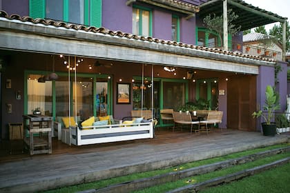 La galería se dotó de calidez y rusticidad con un deck de tablones de madera de laurel, cielo raso de cañas y aberturas de PVC foliado símil madera con pintado exterior.