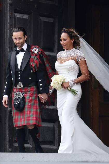 Para su gran día, Mel B vistió un diseño de
la británica Josephine Scott con escote semitransparente e incrustaciones de perlas blancas. Por su
parte, Rory McPhee llevó un smoking remixado
con un kilt de tartán rojo, en homenaje a sus raíces
escocesas.