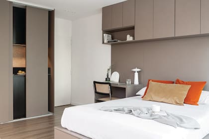 Para una lectura continua, las puertas corredizas que ocultan la cocina se hicieron en el mismo material y color que el escritorio, la cama con cajones y el mueble colgante.