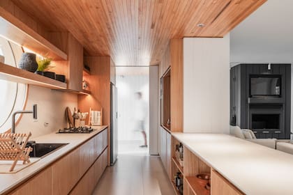 Para unificar la visual, acercaron el acabado de la madera del cielo raso al tono natural del kiri.