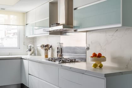 Para unir ambos sectores, copiaron el material de la mesada para hacer la tapa de la mesa (URBANO estudio).