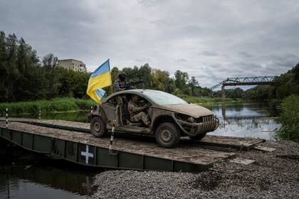 Paracaidistas ucranianos cruzan un puente sobre el río Siverskiy-Donets en la ciudad recientemente liberada de Izium, en Ucrania, el miércoles 14 de septiembre de 2022. (AP Foto/Evgeniy Maloletka)