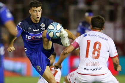 Paradela intenta dominar la pelota ante la marca de Bogado. Huracán y Gimnasia empataron en Parque Patricios.