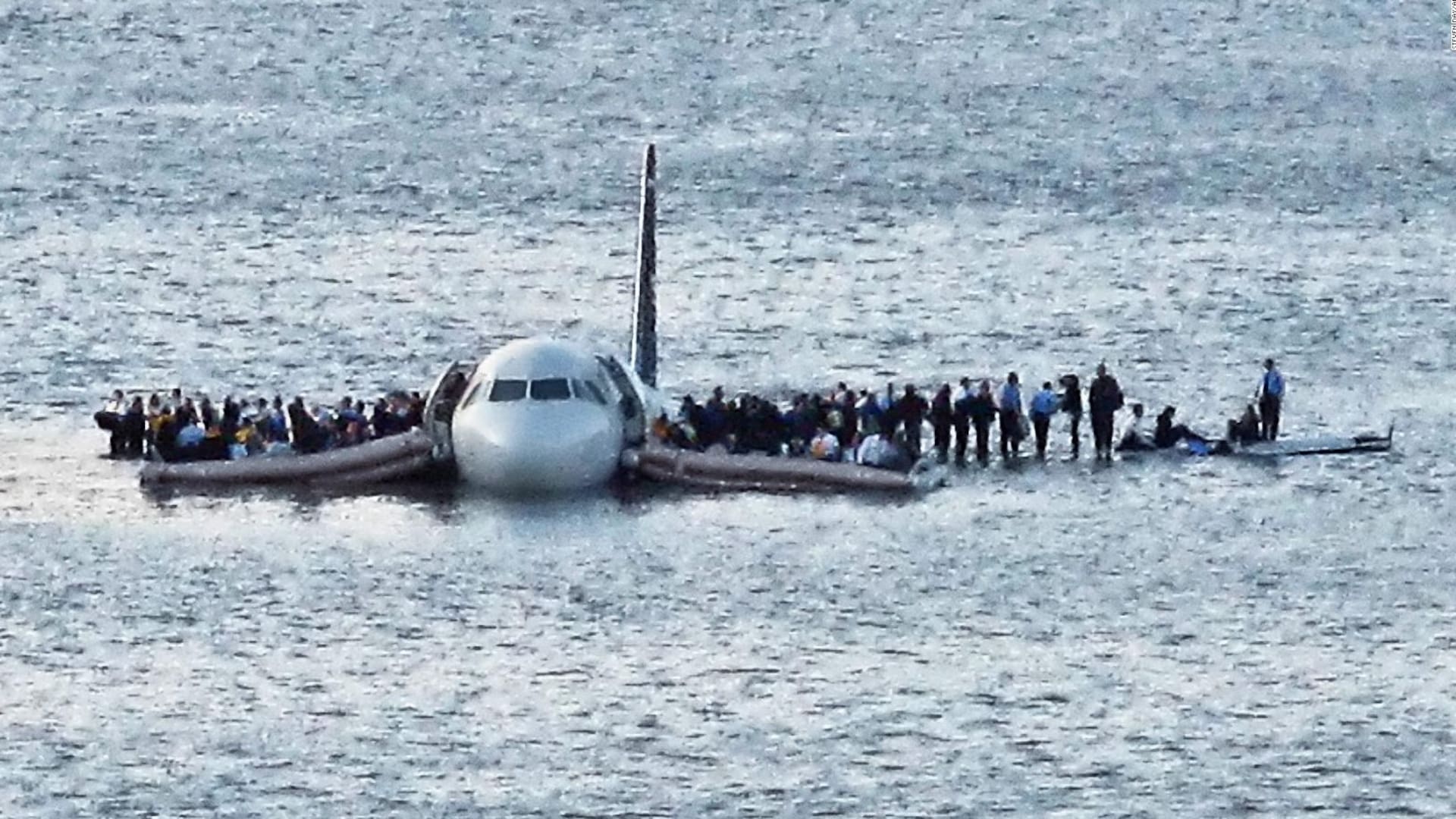 Parados en las alas del avión, los pasajeros aguardan el rescate minutos después de haber amerizado