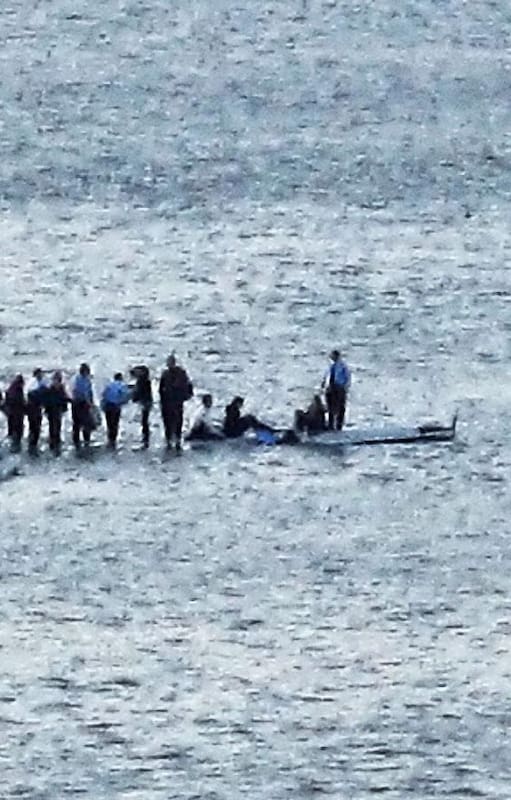 Parados en las alas del avión, los pasajeros aguardan el rescate minutos después de haber amerizado