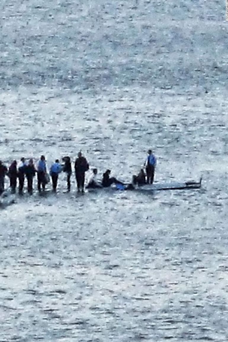 Parados en las alas del avión, los pasajeros aguardan el rescate minutos después de haber amerizado