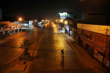 Un hombre cruza una avenida vacía de Eusebio Ayala durante un toque de queda para frenar la nueva pandemia de coronavirus en Asunción