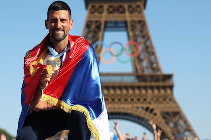 París 2024: Djokovic, arropado por la bandera de Serbia, celebrando el oro olímpico en singles, el único título grande que le faltaba