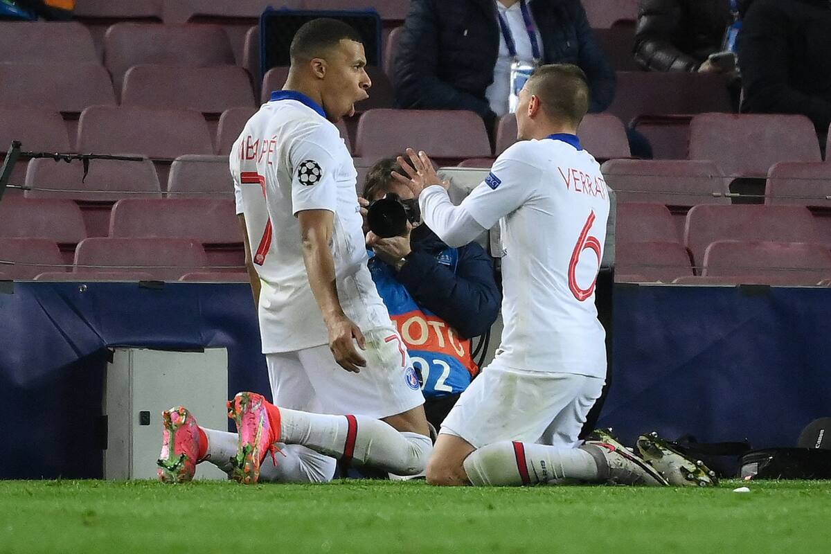 Paris Saint-Germains French forward Kylian Mbappe (L) celebrates with Paris Saint-Germains Italian midfielder Marco Verratti after scoring a goal during the UEFA Champions League round of 16 first leg football match between FC Barcelona and Paris Saint-Germain FC at the Camp Nou stadium in Barcelona