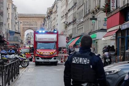 Un oficial de policía se para junto al área acordonada donde ocurrió un tiroteo en París, el viernes 23 de diciembre de 2022