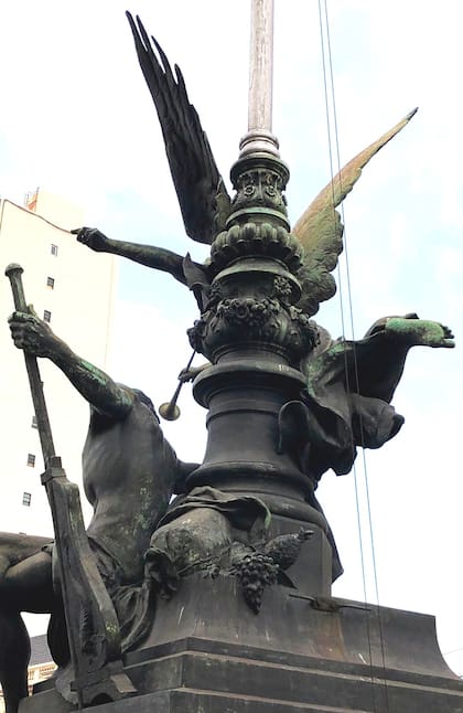 Parte posterior de El Comercio Marítimo, donde se ve la figura masculina con el timón, y la cesta con el racimo de uvas y el ananás