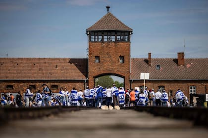 Participantes con banderas israelíes caminan a lo largo de las vías del tren durante la Marcha anual de los Vivos para honrar a las víctimas del Holocausto en el Memorial y Museo Auschwitz-Birkenau en el sitio del campo de concentración de Auschwitz en Oswiecim, Polonia