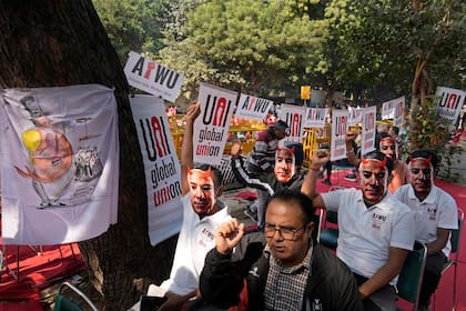 Participantes de una protesta portan máscaras con la imagen del dueño de Amazon, Jeff Bezos, al tiempo que trabajadores de almacén y conductores de entrega se congregaron en la capital, Nueva Delhi, India, para exigir mejores salarios y condiciones laborales, el viernes 29 de noviembre de 2024