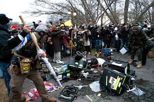 Partidarios de Donald Trump rompen equipos de televisión frente al Capitolio de Estados Unidos el 6 de enero de 2021, en Washington.