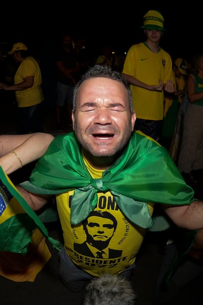 Partidarios del presidente brasileño Jair Bolsonaro, quien se postula para otro mandato, rezan mientras escuchan los resultados parciales luego del cierre de las urnas para las elecciones generales en Brasilia, Brasil, el domingo 2 de octubre de 2022. (Foto AP/Ton Molina)