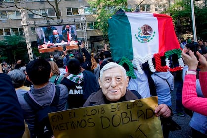 Partidarios del presidente de México, Andrés Manuel López Obrador, le escuchan a través de una pantalla en Nueva York, frente a Naciones Unidas, mientras éste habla ante el Consejo de Seguridad de la ONU el martes 9 de noviembre del 2021. (AP Photo/Eduardo Munoz Alvarez)