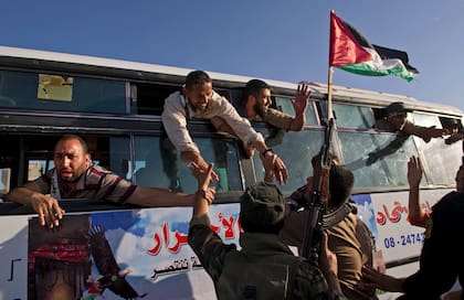 Partidarios saludan a un omnibus lleno de prisioneros que se dirigen a la ciudad de Gaza después de ser liberados a cambio del soldado israelí Gilad Shalit, en el cruce fronterizo de Rafah en el sur de la Franja de Gaza, el 18 de octubre de 2011. Hamás cambió al único soldado israelí por más más de 1000 palestinos, entre ellos Yahya Sinwar, un líder penitenciario que había participado en las negociaciones. Liberarlo fue un gran premio para Hamas, y prometió liberar a más presos.(Lynsey Addario/The New York Times)