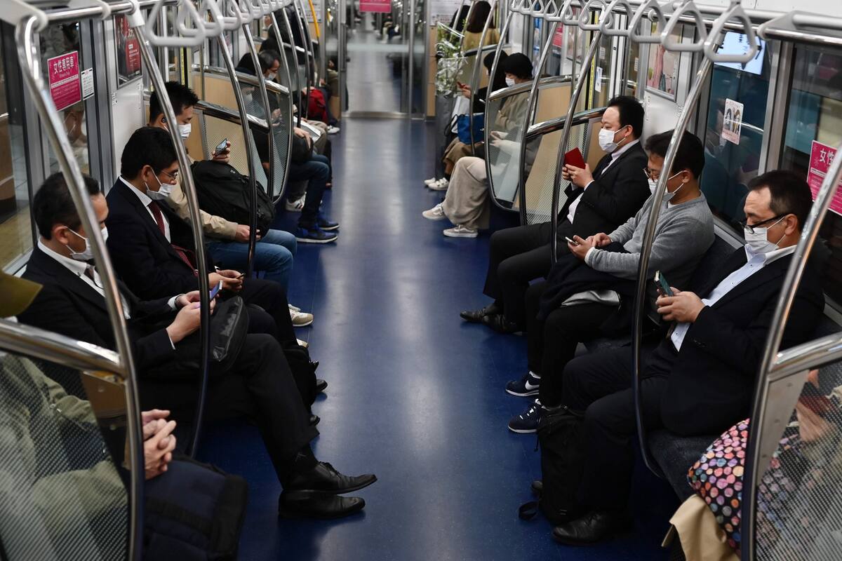 Pasajeros con barbijos en un tren en Tokio