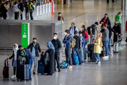 Pasajeros con cubrebocas por el coronavirus se forman para abordar un vuelo a Turquía en el Aeropuerto de Fráncfort, en Alemania, el 11 de mayo de 2021. (AP Foto/Michael Probst)