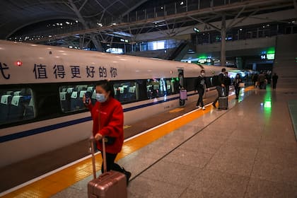 Pasajeros con mascarillas faciales como medida preventiva contra el coronavirus llegan a la estación de tren de Wuhan el 19 de noviembre de 2020