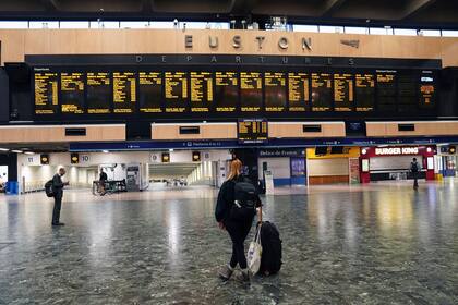 Pasajeros de pie en la estación vacía de London Euston, el jueves 18 de agosto de 2022, durante una huelga de trabajadores ferroviarios. (Stefan Rousseau/PA via AP)