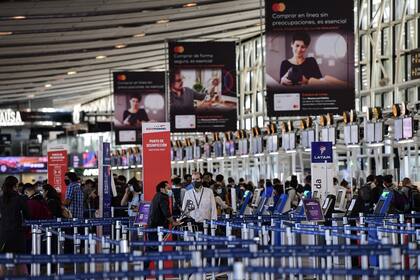 Pasajeros hacen cola en los mostradores del Aeropuerto Internacional Arturo Merino Benítez en Santiago de Chile, hoy