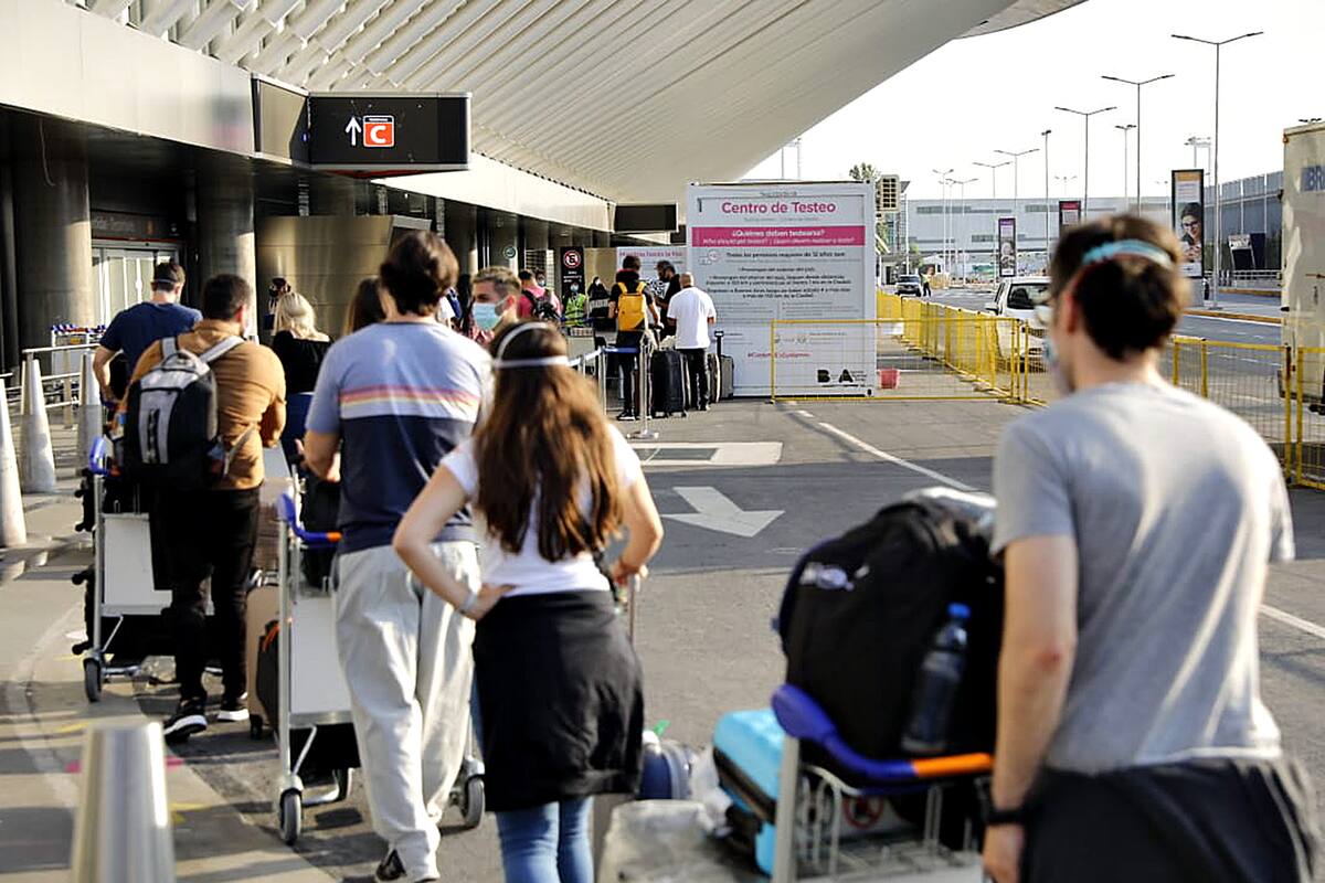 Pasajeros provenientes de San Pablo, Brasil, se someten a los controles PCR en el aeropuerto internacional de Ezeiza