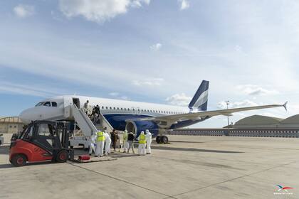 Pasajeros utilizan barbijos en un vuelo para evitar el contagio del coronavirus, aunque el doctor David Powell dice que es un método poco ediciente para evitar la propagación