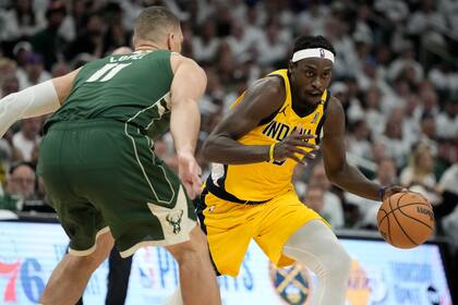 Pascal Siakam, de los Pacers de Indiana, trata de driblar a Brook López, de los Bucks de Milwaukee, en el segundo encuentro de la serie de playoffs, disputado el martes 23 de abril de 2024 (AP Foto/Morry Gash)
