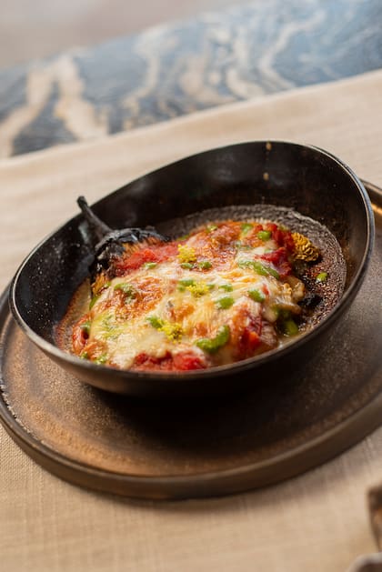 Pastas, preparaciones al horno de barro y vegetales de la huerta se fusionan en una cocina a la vista, con vinos expresivos centrados en el Malbec como variedad emblemática