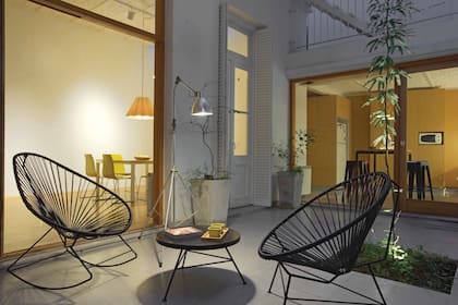 Junto a la mecedora 'Acapulco', lámpara'Trípode' con brazo de aluminio y embutido de piso 'Frog' con lámpara Gu10 LED (Onic iluminación).