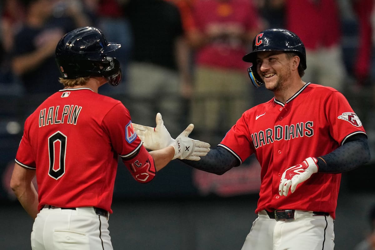 Patrick Bailey, derecha, de los Guardianes de Cleveland, es felicitado por Petey Halpin (0) después