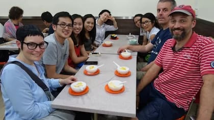 Paul Chan (segundo a la izquierda) lleva a un grupo de turistas a probar un postre tradicional en los días anteriores a la pandemia de covid-19.