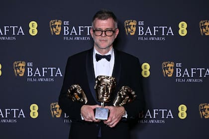 Paul Thomas Anderson con las estatuillas a mejor película, director y guion adaptado