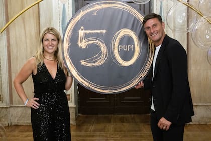 Paula y Javier posan minutos antes del comienzo de la celebración. La mujer del ex defensor eligió un mono largo de pailletes con escote pronunciado.