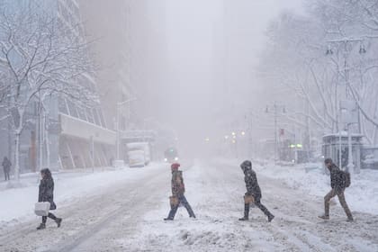 Peatones cruzan la calle 42 cerca de Bryant Park durante una tormenta de nieve, el lunes 23 de febrero de 2026, en Nueva York. (Foto AP/Seth Wenig)