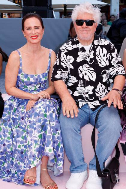 Pedro Almodóvar junto a la actriz española Aitana Sánchez-Gijón, que apostó por una de las creaciones más coloridas de la casa: un vestido blanco estampado con amapolas azules y detalles de hojas verdes, de largo midi, ajustado en la cintura y con falda con vuelo
