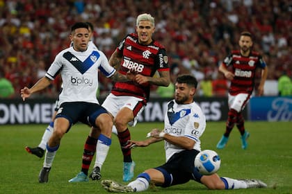 Pedro remata entre Francisco Ortega y Matías De los Santos; el delantero de Flamengo es el goleador de la Copa Libertadores, con 12 festejos en la misma cantidad de partidos