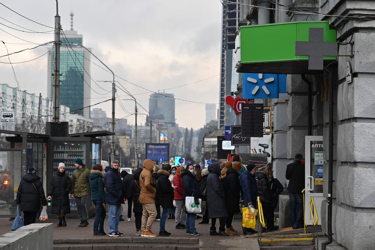 People queue to a pharmacy in Kyiv on February 24, 2022. - Russian President Vladimir Putin launched a full-scale invasion of Ukraine on Thursday, forcing residents to flee for their lives and leaving at least 40 Ukrainian soldiers and 10 civilians dead. Russian air strikes hit military facilities across the country and ground forces moved in from the north, south and east, triggering condemnation from Western leaders and warnings of massive sanctions. (Photo by GENYA SAVILOV / AFP)