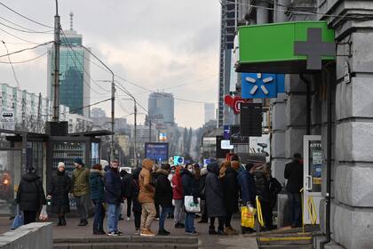 People queue to a pharmacy in Kyiv on February 24, 2022. - Russian President Vladimir Putin launched a full-scale invasion of Ukraine on Thursday, forcing residents to flee for their lives and leaving at least 40 Ukrainian soldiers and 10 civilians dead. Russian air strikes hit military facilities across the country and ground forces moved in from the north, south and east, triggering condemnation from Western leaders and warnings of massive sanctions. (Photo by GENYA SAVILOV / AFP)