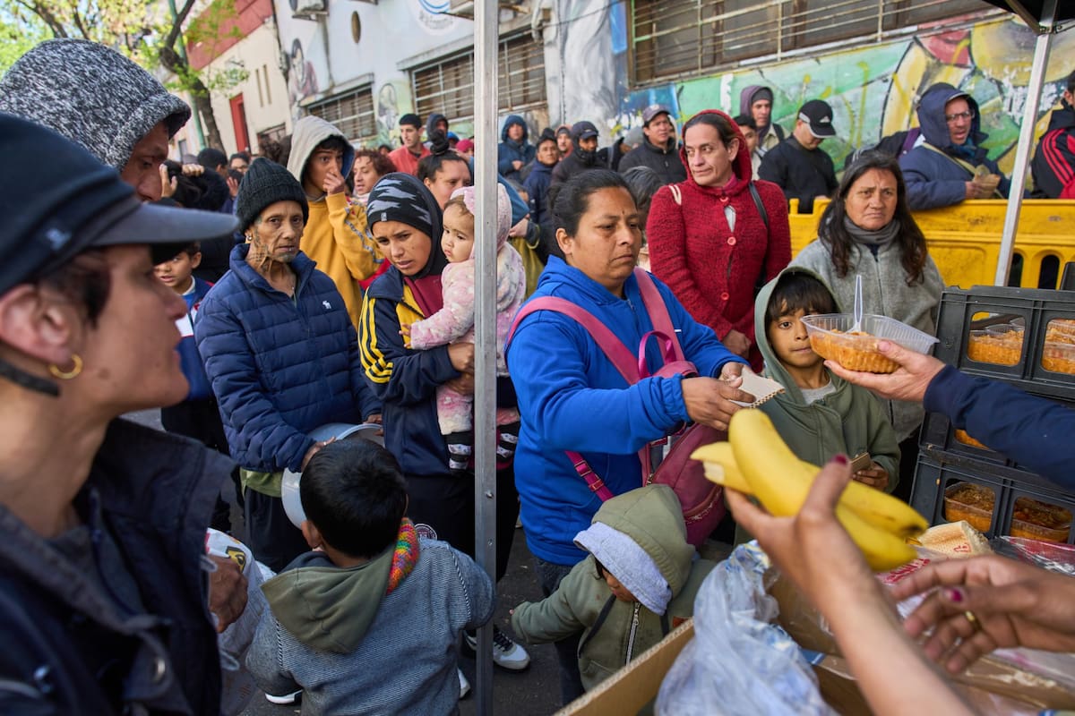 People receive free meals distributed by the Union of Workers of the Popular Economy in Buenos Aires, Argentina, Wednesday, Sept. 23, 2026. (AP Photo/Rodrigo Abd)