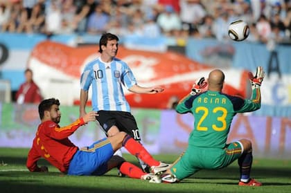 Pepe Reina arrodillado en Buenos Aires ante el gol de Messi, con Piqué por el piso; fue en septiembre de 2010, Argentina 4 vs. España 1, la tarde de la primera gran ovación para la Pulga en su país