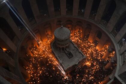 Peregrinos cristianos ortodoxos sostienen velas durante la ceremonia del Fuego Sagrado, un día antes de la Pascua ortodoxa, el sábado 15 de abril de 2023 en la Iglesia del Santo Sepulcro en la Ciudad Vieja de Jerusalén, donde muchos cristianos creen que Jesús fue crucificado y enterrado antes de resucitar. (AP Foto/Tsafrir Abayov)