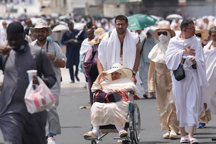 Peregrinos salen después de orar, fuera en la Gran Mezquita, durante la peregrinación anual de haj en La Meca, Arabia Saudí, el jueves 13 de junio de 2024. (AP Foto/Rafiq Maqbool)