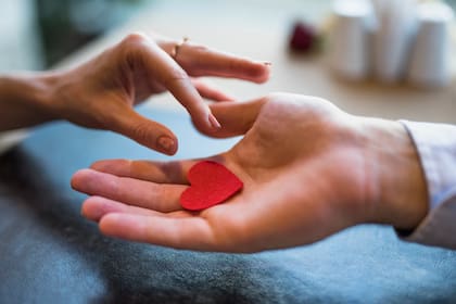 Persona sostiene un corazón de papel en su mano